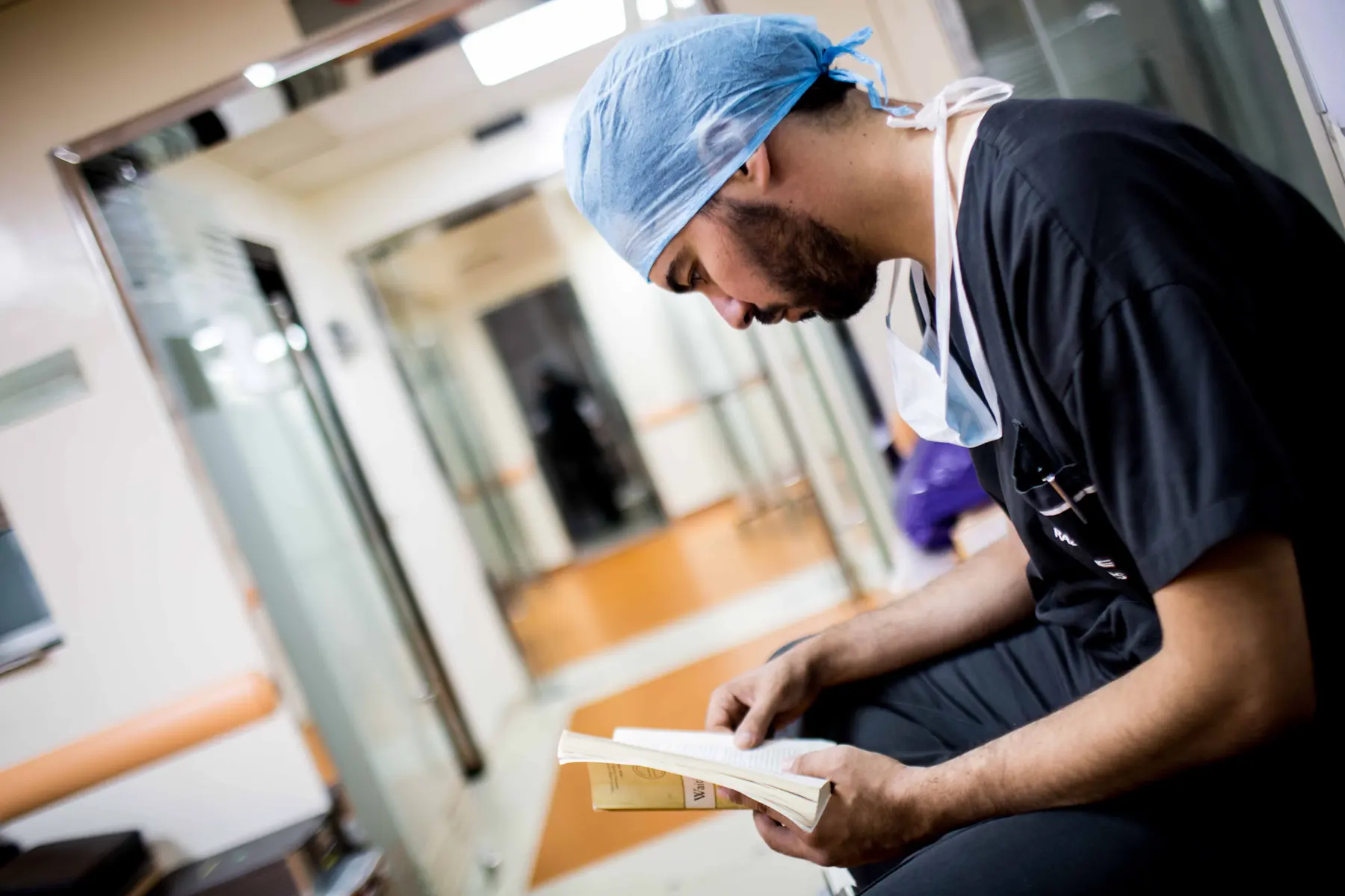 A Caribbean medical student studying between cases in scrubs